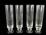 CRISTAIS, quatro (4) taças flutes confeccionadas em cristal translucido com lapidação de palmas e elementos geométricos em baixo relevo, haste torneada, apoiada sobre base circular, medindo 17,5x5cm.
