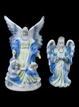 ARTE SACRA, duas (2) esculturas confeccionadas em porcelana na tonalidade branca com pintura na tonalidade azul representando figuras angelicais, sendo 1 ladeado por crianças, medindo 14cm e 10,5cm.