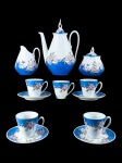 PORCELANA REAL, serviço para café com oito (8) peças confeccionadas em porcelana na tonalidade branca, espessas faixas na tonalidade azul com guirlanda floral em policromia com realces em ouro, sendo: A) 1 bule para café, medindo 20,5cm de altura, B) 1 açucareira com quebra na pega da tampa, medindo 10x6cm, C) 1 cremeira, medindo 11x7x4cm e D) 5 xícaras, 4 com seus respectivos pires, medindo 5,5x7x6cm.