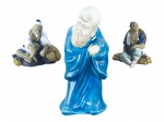ESCULTURAS, lote com três (3) esculturas orientais de modelos, tamanhos e decorações distintas, sendo: A) 1 sábio chinês em biscuit com vestes vitrificadas na tonalidade azul, medindo 21,5cm de altura, B) 1 pescador em cerâmica vitrificada em policromia, medindo 10,5x11cm e C) 1 lenhador em cerâmica vitrificada em policromia, medindo 10x9,5cm.