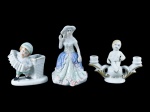 ESCULTURAS, lote com três (3) peças confeccionadas em porcelana de modelos, tamanhos e decorações distintas, sendo: A) 1 pequeno candelabro para 2 velas representando musicista, medindo 7,5x9,5cm, B) 1 dama antiga esmaltada em policromia, medindo 10,5cm de altura e C) 1 floreira representando musicista, apresenta fio de cabelo na borda, medindo 7,5x6cm.