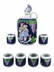 PORCELANAS, conjunto para vinho com sete (7) peças confeccionadas em porcelana na tonalidade branca da marca CERAMARTE, decorado por casal em taberna, cachos de uva e folhas de parreira em policromias sobre fundo azul cobalto, pega da tampa representando capacete medieval, sendo: A) 1 garrafa, medindo 21cm de B) 6 copos para vinho, medindo 5,5x5cm.