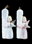 WEISS, dois (2) castiçais confeccionados em faiança vitrificada representando anjos, ladeados por vela com pintura policromada, 1 apresenta discretas falhas na vitrificação, medindo 12,5cm de altura,