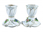 PORCELANA VIEIRA DE CASTRO, par (2) de castiçais confeccionados em porcelana na tonalidade branca, decorado por flores e folhagens em relevo e policromia, gomos e realces filetados em ouro, ambos com discretos bicados nas flores, medindo 7,5cm de altura.
