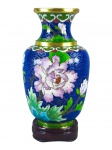 CLOISONNÉ, um (1) pequeno vaso confeccionado em cloisonné com rica decoração floral e vegetalista sobre fundo azul com nuvens realçadas em douração, apoiada sobre peanha em madeira, medindo 14cm de altura.