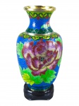 CLOISONNÉ, um (1) pequeno vaso confeccionado em cloisonné com rica decoração floral e vegetalista sobre fundo azul com nuvens realçadas em douração, apoiada sobre peanha em madeira, medindo 14cm de altura.