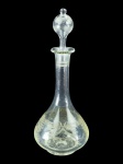CRISTAL, uma (1) licoreira bojuda confeccionada em cristal translucido com lapidação de guirlanda geométrica, laçarotes, flores e folhagens em baixo relevo, medindo 34cm de altura, leves sinais de fungo interno.