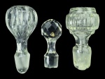 CRISTAIS e VIDRO, lote com três (3) tampas de garrafas/licoreiras de modelos, tamanhos e decorações distintas, sendo 2 em cristal e 1 em vidro, medindo 7,5cm bicado na ponta, 9cm com batidas laterais e 10cm.