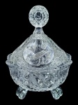 CRISTAL, uma (1) bomboniere confeccionada em cristal translucido, lapidado por estrelas, caneluras, gomos, pássaros e folhagens em baixo relevo com pega em vazados e pés tripoides, medindo 24x18,5cm,