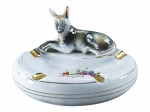 PORCELANA, um (1) cinzeiro oval confeccionado em porcelana na tonalidade branca, encimado por carrocho com pintura furtacor, decoração de flores e folhagens em policromia e inscrição AMIZADE com filetes e realces em ouro, medindo 12x19x14cm. Leves falhas na douração.