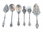 METAL PRATEADO, seis (6) peças confeccionadas em metal espessurado a prata com cabo ricamente cinzelada por elementos vegetalistas em vazados, sendo 1 tesoura para bolo, 2 colheres para arroz, 1 colher e 1 garfo para salada e 1 pá para bolo, apresentam falhas na prateação.