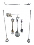 METAL PRATEADO, oito (8) peças diversas em metal prateado, incluindo colheres de souvenir, hastes longas para coquetel/serviço, espátulas e peças ornamentais, com exemplares identificados com brasões e temas regionais, incluindo Portugal e Chile, além de peça com decoração floral em relevo. Vendidas no estado da foto.