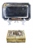 METAL PRATEADO e DIVERSOS, lote com duas (2) peças, sendo: A) 1 pequena bandeja retangular confeccionada em metal prateado com incrustação de laçarote em metal dourado, medindo 24,5x15cm e B) 1 caixa porta joias confeccionada em madeira com incrustações de placas de resina e madre pérola, pequenos bicados, interior com forração em tecido aveludado na cor vermelha, medindo 4,5x13,5x9,5cm