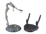 DIVERSOS, duas (2) peças, sendo: A) um (1) suporte para relógio de bolso de inspiração oriental, com base circular trabalhada e haste ornamentada por figura de dragão, medindo 16,5cm e B) um (1) suporte para xícara em madeira escura para apoio/exposição de prato, medindo 8,5x9x10cm.