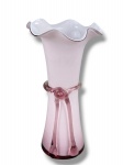 MURANO, um (1) vaso confeccionado em vidro de MURANO na tonalidade rosa, corpo decorado por laçarote e bordas em ondulações, medindo 21cm de altura.