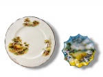 FAIANÇAS, lote com dois (2) pratos decorativos confeccionados em faiança vitrificada, sendo: A) 1 ALFREAD MEAKIN, na tonalidade creme com pintura de paisagens campestres com figuras em policromia e borda filetada em ouro, medindo 20cm de diâmetro, apresenta restauro na borda e B) 1 de origem japonesa, na tonalidade branca, decorado por cena campestre com figuras em policromia e borda em ondulações, sinais de craquele e marcas do tempo, medindo 13cm.
