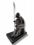 DORKA, uma (1) escultura confeccionada em bronze representando Dom Quixote sentado, datada de 1975, apoiado sobre base retangular em mármore preto com placa metálica, medindo 53,5x30x18cm.  Necessita solda na lança.