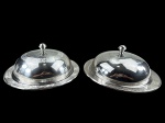 METAL INOX, lote com duas (2) clouches com bandejas redondas confeccionadas em aço inox da manufatura PRATINOX, decoradas por guirlanda floral e vegetalista, medindo 13x31cm, sinaios de uso.