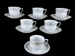 PORCELANAS, seis (6) xícaras para chá com seus respectivos pires confeccionadas em porcelana na tonalidade branca com moldagem em gomos torcidos, decoradas por guirlanda floral e vegetalista com filete na cor cinza, medindo 7x10,5x8,5cm.