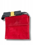 SALVATORE FERRAGAMO, uma (1) bolsa/clutch vintage, em camurça vermelha, com detalhe superior em laço de gorgurão preto e placa metálica dourada com inscrição da marca. Interior em material preto, com etiqueta Salvatore Ferragamo Boutique  Made in Italy, compartimento com zíper e fechamento frontal por botão de pressão. Peça com sinais de uso, necessita limpeza, medindo 17x16,5cm.