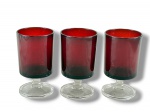VIDROS, três (3) taças para vinho confeccionados em vidro, possivelmente francês, na tonalidade vermelha, haste curta e cilíndrica, apoiada sobre base circular, 1 bicado na base, medindo 9,5x5cm.