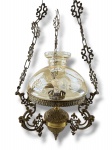 LUSTRE, um (1) lustre para uma lâmpada confeccionado em bronze com cinzelado de elementos vegetalistas, hastes curvas com rostos de Puttinos, sustentado por correntes em vazados, cúpula em vidro nacarado com lapidação floral em baixo relevo, medindo 81x33cm.