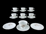PORCELANA SCHMIDT, sete (7) xícaras com seus respectivos pires, sendo 6 para café e 1 para chá confeccionadas em porcelana na tonalidade branca com pintura de elementos florais em policromia e filetes em prata, 1 para café bicado na borda, café medindo 5,5x8,2x7cm e chá 7x11x9,5cm com fio de cabelo na base.