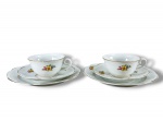 PORCELANA STEATITA, par (2) de trios para chá, sendo: A) 2 xícaras para chá com seus respectivos pires, 1 com fio de cabelo, medindo 5x11,5x9,5cm e B) 2 pratos para bolo, medindo 19,5cm, confeccionados em porcelana na tonalidade branca com pintura de elementos florais em policromia, bordas filetadas em ouro.
