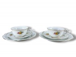PORCELANA STEATITA, par (2) de trios para chá, sendo: A) 2 xícaras para chá com seus respectivos pires, 1 bicada na borda, medindo 5x11,5x9,5cm e B) 2 pratos para bolo, medindo 19,5cm, confeccionados em porcelana na tonalidade branca com pintura de elementos florais em policromia, bordas filetadas em ouro.