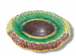 FAIANÇA, um (1) travessa para pão em confeccionada majólica vitoriana do século XIX, apresentando um padrão em relevo de feixes de trigo dourado sobre fundos verdes, com uma medalha central marrom, apresenta sinais de uso, medindo 33x28cm.