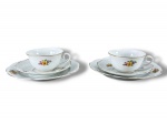 PORCELANA STEATITA, par (2) de trios para chá, sendo: A) 2 xícaras para chá com seus respectivos pires, medindo 5x11,5x9,5cm e B) 2 pratos para bolo, medindo 19,5cm, confeccionados em porcelana na tonalidade branca com pintura de elementos florais em policromia, bordas filetadas em ouro.