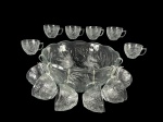 VIDROS, conjunto para ponche com treze (13) peças confeccionadas em vidro translucido com moldagem de cachos de uva e folhas de parreira em relevo, sendo: A) 1 poncheira, medindo 15x32cm e B) 12 canecas para ponche, medindo 6,5x11x9cm. Ausência da concha.