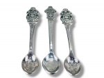 METAL PRATEADO, três (3) colheres souvenir de coleção confeccionadas em metal espessurado a prata, com inscrições Rolex, Bucherer, Lucerne e Watches, cabos lisos com gravações e terminais em relevo decorados com brasões e motivo de concha. Conchas com gravações decorativas em baixo-relevo.