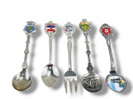 METAL PRATEADO, cinco (5) peças, sendo 4 colheres e 1 garfo souvenir de coleção confeccionados em metal espessurado a prata destacando os brasões da Holanda (Nederland), da antiga Iugoslávia, de Liechtenstein e da Suécia (Sverige).