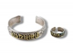 JOIAS, conjunto com duas (2) peças confeccionadas em PRATA DE LEI com cinzelado do mantra budista Om Mani Padme Hum em relevo com filete em ouro, elos ajustáveis, cinzelado por laços e elementos geométricos, peso 38g.
