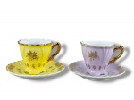 PORCELANA SCHMIDT, duas (2) xícaras para café de coleção com seus respectivos pires confeccionados em porcelana na tonalidade branca com pintura na tonalidade lilás e amarela, decorada por elementos florais e vegetalistas filetados em ouro, medindo 5x6,5x5cm.