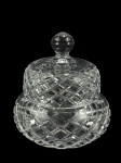 CRISTAL, uma (1) bomboniere confeccionada em cristal translúcido com lapidação de losangos em baixo relevo com pega da tampa esférica, medindo 15,5x10cm.