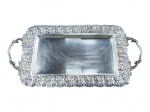 METAL PRETEADO, uma (1) bandeja retangular confeccionada em metal espessurado a prata, borda ricamente cinzelada por elementos vegetalistas em vazados, medindo 42x22,5cm.