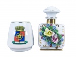 PORCELANAS, lote com duas (2) peças confeccionadas em porcelana na tonalidade branca, sendo: A) 1 porta canetas com brasão colorido do Instituto Militar de Engenharia, borda com filete dourado, medindo 8,5x6cm e B) 1 perfumeiro com rica decoração floral em policromia e relevo com realces filetados em ouro, interior com cortiça solta, medindo 13,5cm de altura, bicados na flores.