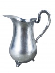 METAL PRATEADO, uma (1) jarra confeccionada em metal espessurado a prata da manufatura EBERLE, corpo bojudo, alça vazada, apoiada sobre pés finalizados em volutas, medindo 21x17x9,5cm.