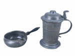 ESTANHOS, lote com duas (2) peças confeccionadas em estanho, sendo: A) 1 tankard com cinzel de faixas horizontais, alça vazada e tampa escalonada com mossa na base, medindo 18cm de altura e B) 1 leiteira com alça lateral em madeira torneada de tom escuro, medindo 25x14x11cm. Ambas peças com desgastes no estanho.