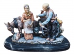ESCULTURA, um (1) grupo escultórico representando casal de idosos com uma carroça e um burro, confeccionado em resina esmaltada em policromia, base oval, também, em resina, medindo 19x30x17cm.