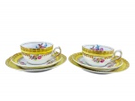 PORCELANA SCHMIDT, par (2) de trios para chá, sendo: A) 2 xícaras para chá com seus respectivos pires, medindo 5x11x8,5cm e B) 2 pratos para bolo, medindo 17cm, confeccionados em porcelana nacional na tonalidade branca, decorados por espessas faixas na tonalidade amarela, pintura de flores e folhagens em policromia, guirlanda e filetes em ouro.