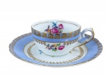 PORCELANA SCHMIDT, duas (2) peças, sendo: A) 1 xícara de coleção sem pires, medindo 5x11,5x9cm e B) 1 prato para bolo, medindo 17cm, confeccionados em porcelana nacional na tonalidade branca, decorados por espessas faixas na tonalidade azul, pintura de flores e folhagens em policromia, guirlanda e filetes em ouro.