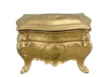 METAL DOURADO, uma (1) caixa porta joias confeccionada em metal com pintura dourada, cinzelado por elementos vegetalistas e saia em recortes, interior com tecido aveludado na tonalidade vermelha, marcado DÉPOSE no fundo, medindo 11x15x9,5cm.