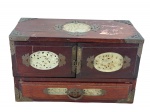 DIVERSOS, uma (1) caixa porta-joias chinesa confeccionada em madeira. Formato retangular, 2 portas com 2 gavetas internas e 1 externa, ricamente decorada com embutidos de pedra em tom esverdeado sulando jade, talhados com flores e folhagens em vazados, fechadura e aplicações em placa de bronze (ausência das laterais), interior com forração em tecido aveludado com desgastes, gaveta externa necessita reparo, possui falhas no verniz, caixa musical funcionando, porém, necessita revisão, medindo 19x32x15cm.