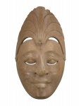 DIVERSOS, uma (1) máscara decorativa confeccionada em madeira clara entalhada a mão representando figura balinesa, lascado na parte traseira, medindo 25,5x15,5cm.