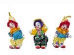 COLECIONISMO, três (3) palhaços de coleção confeccionados em porcelana esmaltada na tonalidade branca, vestes em tecido em rica policromia, medindo 11cm de altura.
