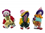 COLECIONISMO, três (3) palhaços de coleção, rosto, pés e mãos confeccionados em porcelana esmaltada na tonalidade branca, vestes em tecido em rica policromia, medindo 11cm de altura.