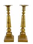 METAL DOURADO, par (2) de castiçais confeccionados em metal dourado, haste torneada, decorada por esferas, base cônica encimada por esfera, bobeches em ondulações, medindo 28cm de altura.